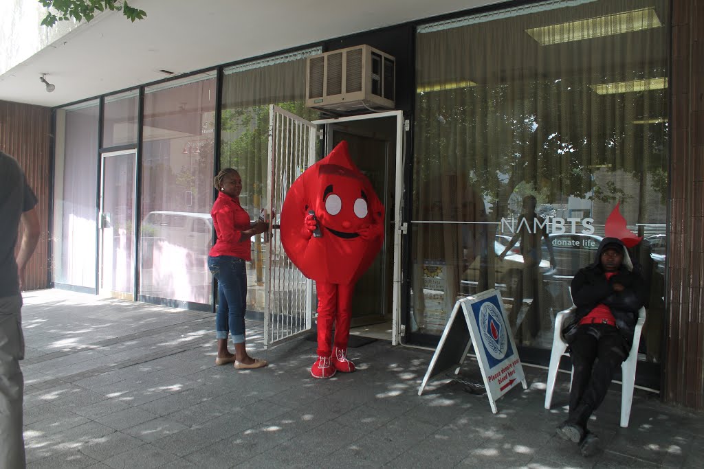 Werbung für Blutspenden - wenn ich die schriftlichen Äußerungen zu der verkleideten Person richtig in Beziehung setze - an der Independence Avenue in Windhoek am 19. November 2013 morgens by Wolfgang Hanko