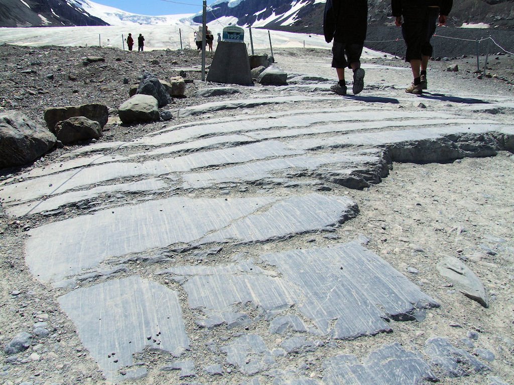 Polished, scored rocks immediately below the toe of Athabasca Glacier, and a marker saying "The glacier was here in 1992" by Idle Moor