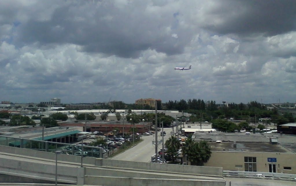 Airplane approaching to Miami airport seen from Miami Car Rental Intermodal Facility by John M Lopez