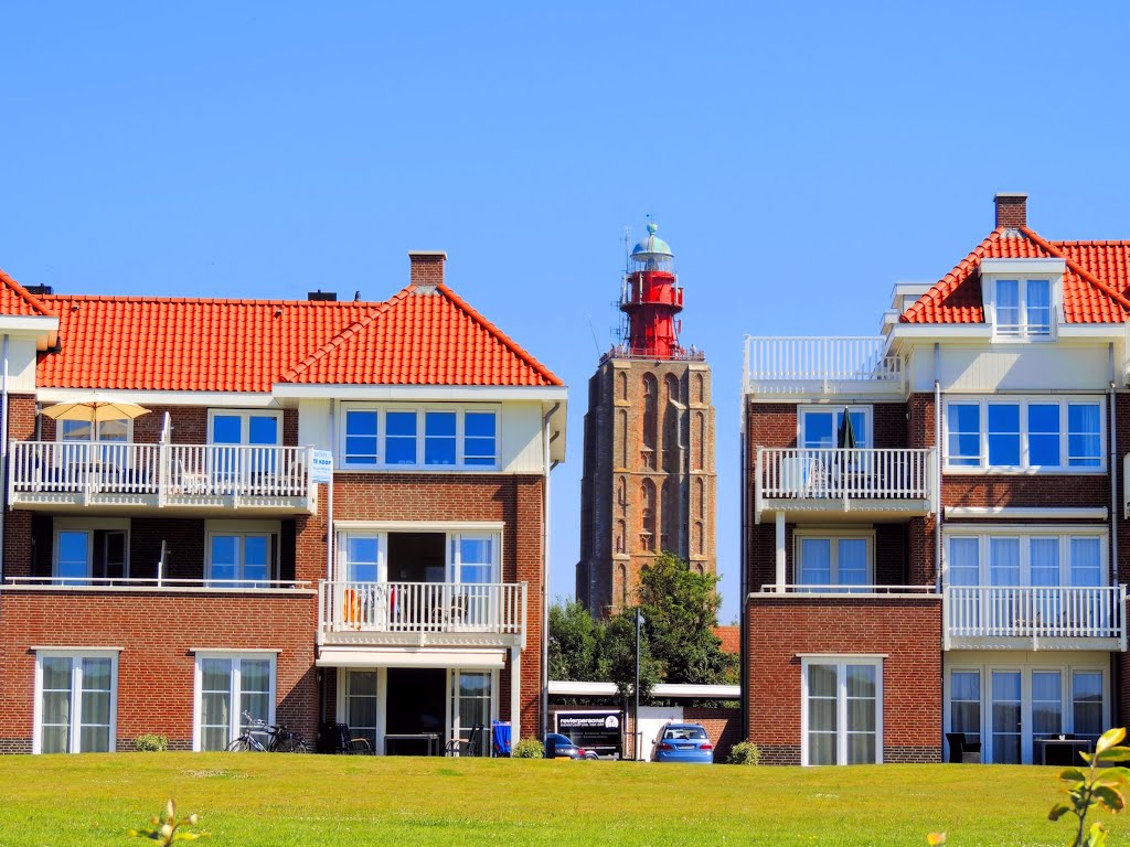 De grote vuurtoren van Westkapelle gezien van tussen de gebouwen van het Badmotel by David Laaglander