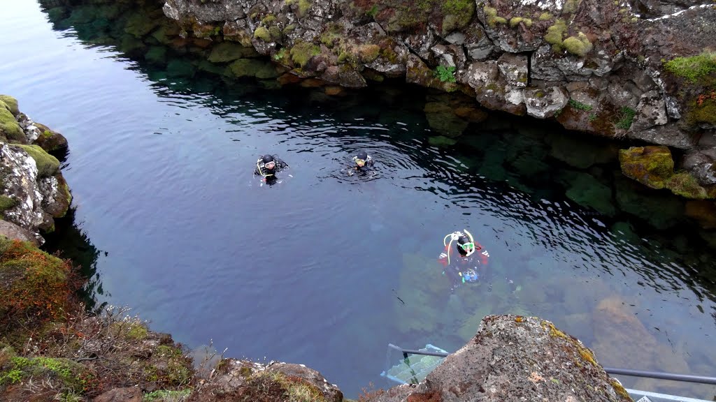 Divers diving in the rift in the Mid-Atlantic Ridge, Þingvellir National Park, Iceland by John Eby