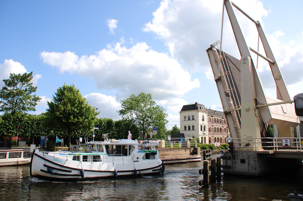 Busy yacht traffic at the touristic Mijndense sluices at Nieuwersluis with Militairy prison building at the background by Henk Monster