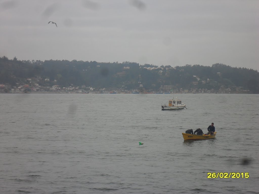 Vista de pescadores artesanales en el bote amarillo y turística localidad de Coliumo al fondo. by fotomau84