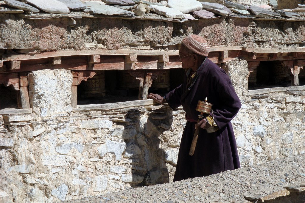 Man turning the prayer wheels at Lamayuru by Bob Witlox