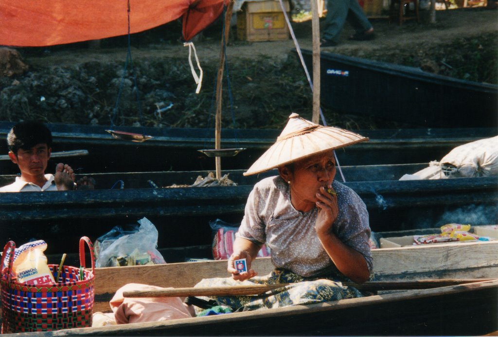 Old woman smoking in a boat, Inle Lake by fabio.tosetti