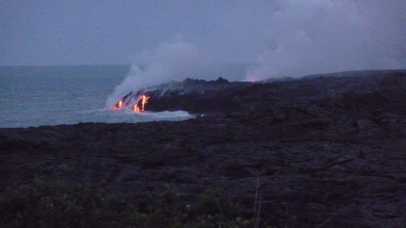 Lava flowing into the sea at dusk by Andy Goss