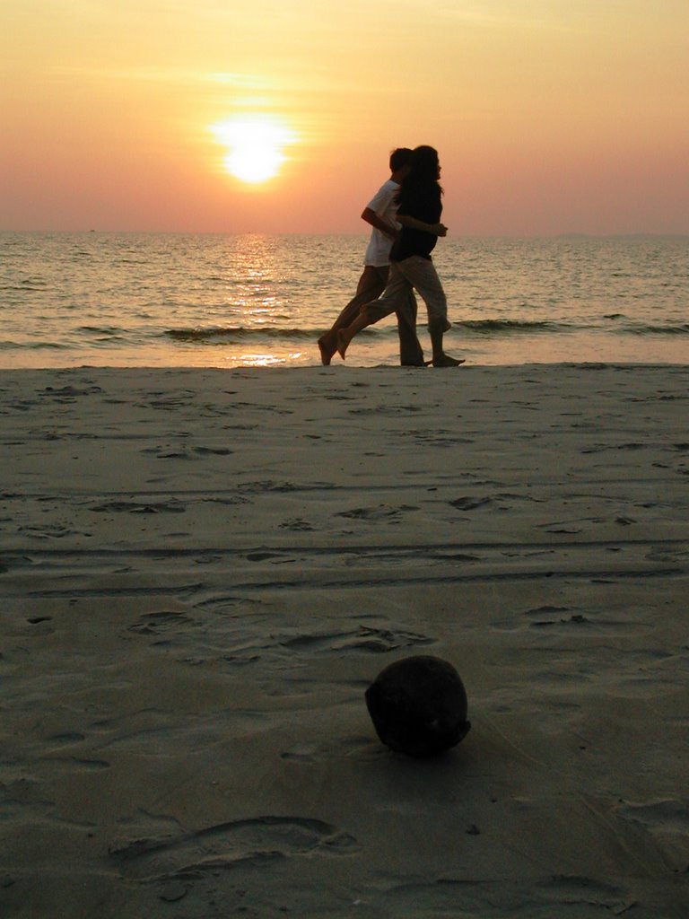 A couple jog past a coconut, Occheutal Beach, Cambodia by Gerry Aitken