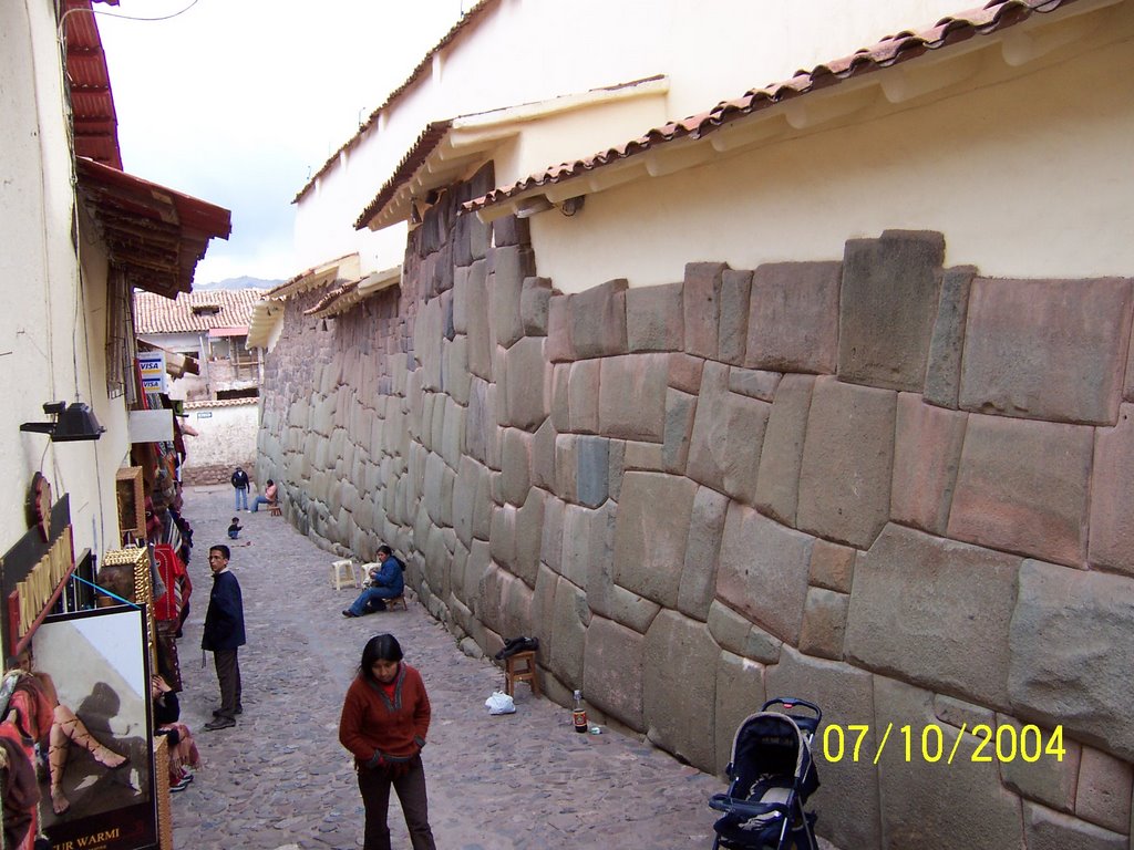 Muro de piedra y tiendas al frente. Cusco. by Wilfredo Valverde