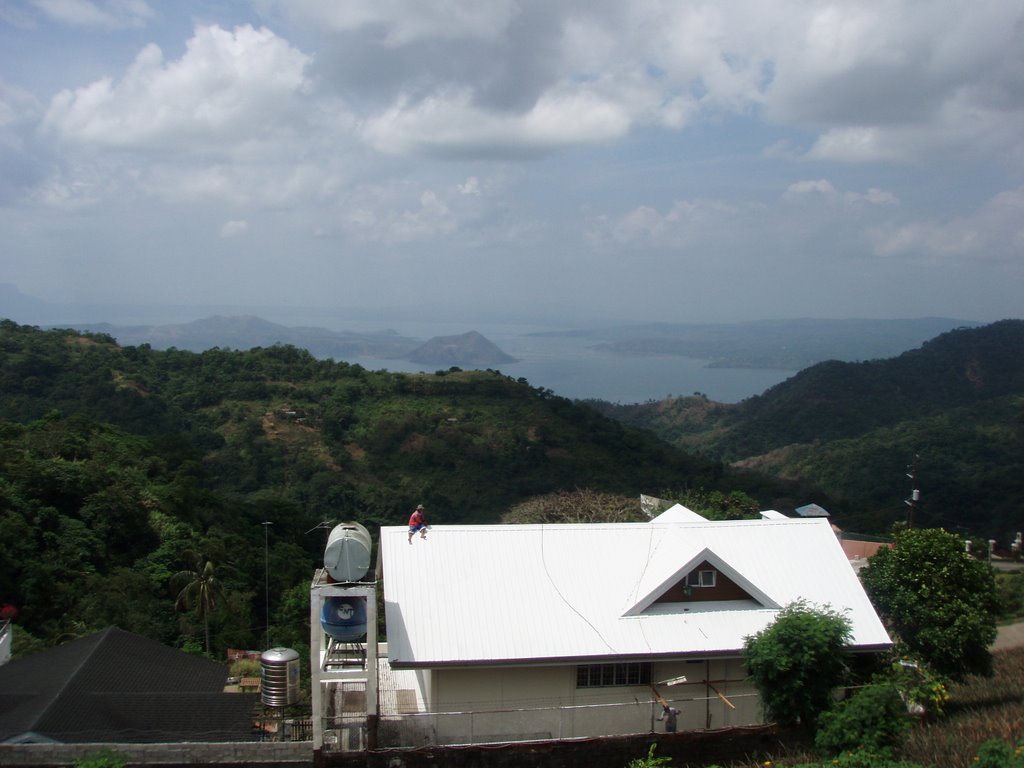 Man sitting on roof looking out at Taal Lake and Volcano, Tagaytay, Philippines by Sonya Brunt