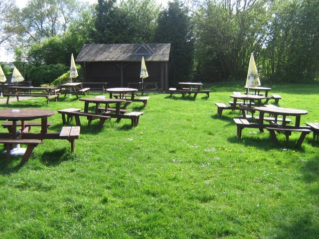 The sets of wooden tables and parasols, outside on the grass by Robert'sGoogleEarthPictures