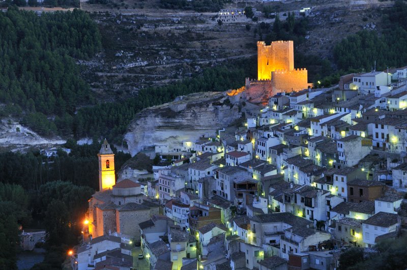 La Manchuela (district): Night view of Alcalá del Júcar, crowned by its castle; to the left the Iglesia de San Andrés church by www.iberimage.com