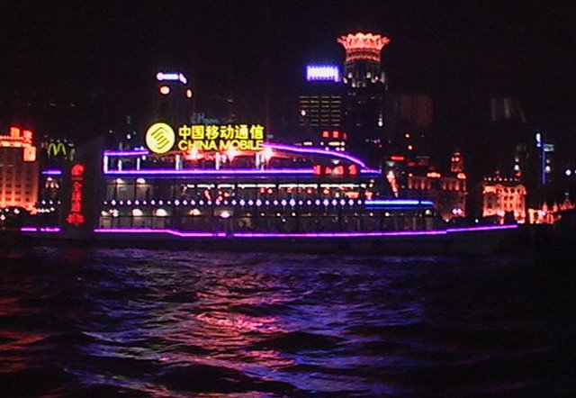 Shanghai and river boat lights (China Mobile) by Joe Gattuso