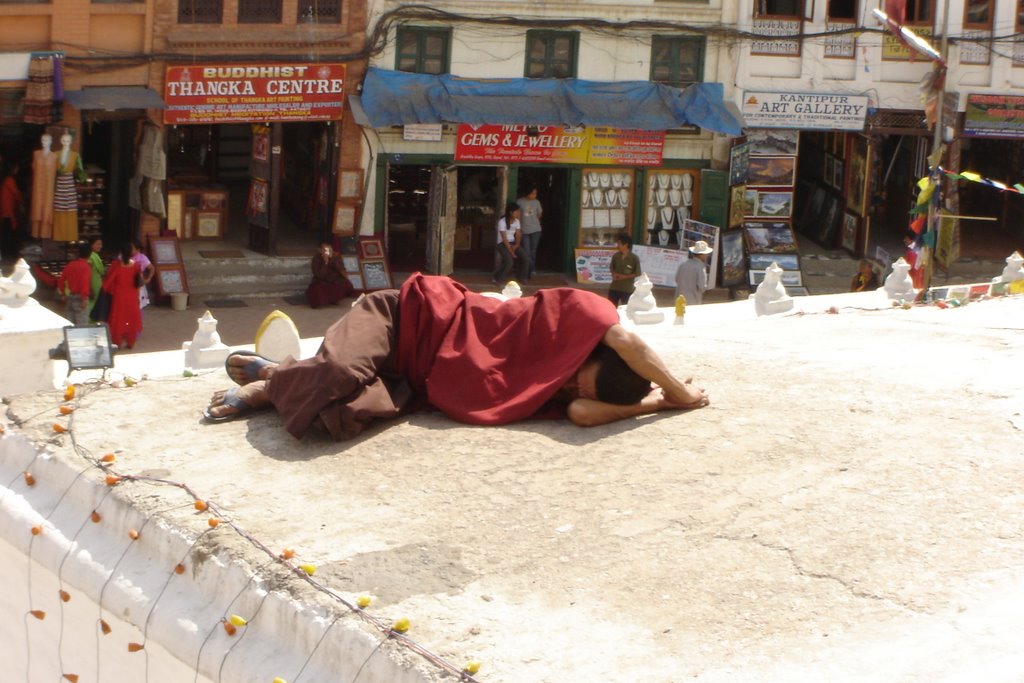 A monk taking a nap at Bodhnath stupa by Bob Witlox