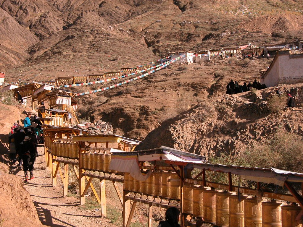 Thousands of pilgrims walk a circuit around the monastery passing the picture of the red buddha by Philipp Gaertner