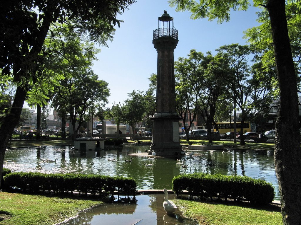 A light tower in the middle of a pond in the park by fotokönig