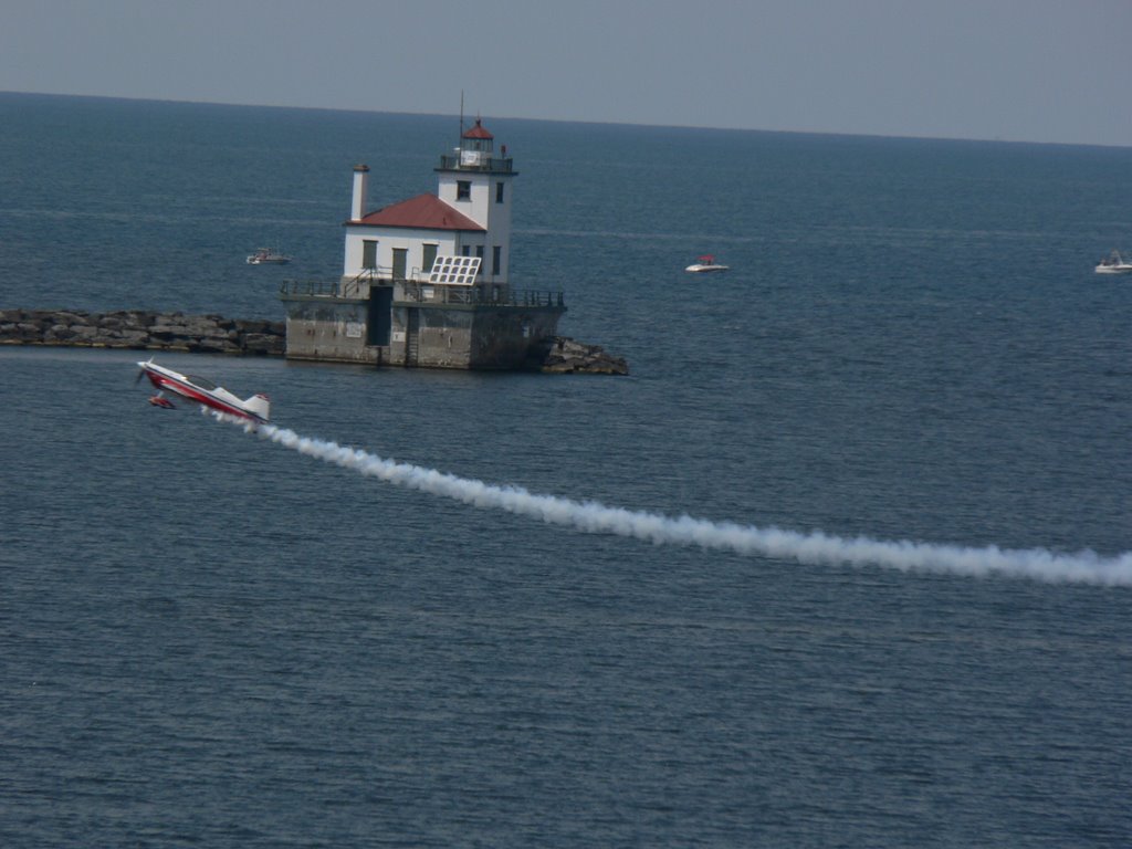 Plane flies past the lighthouse - 2005 Airshow by ravind