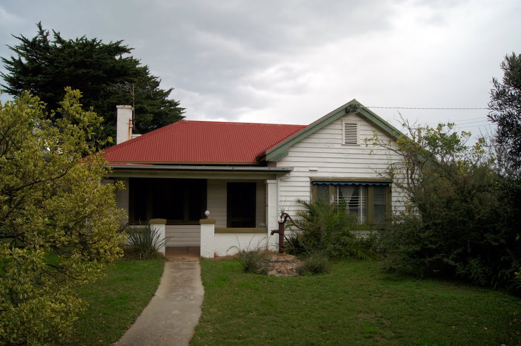 This weatherboard cottage near the main Sorrento shopping centre still has the original water pump in the front yard (2010) by Muzza from McCrae