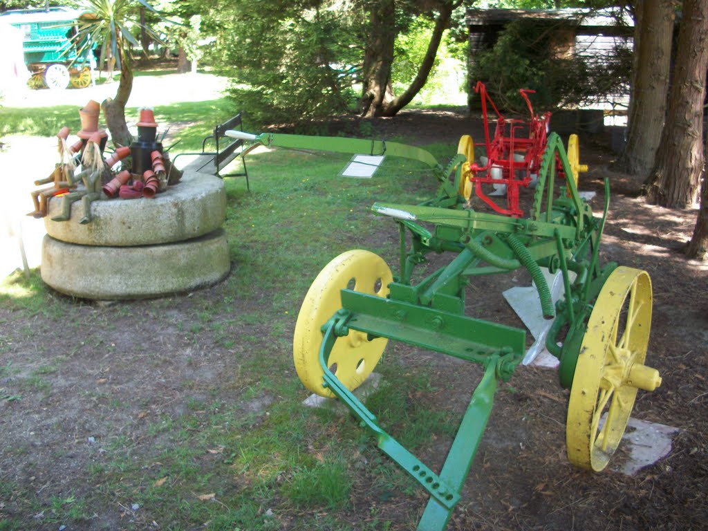 The farm machines, painted red and green with yellow wheels by Robert'sGoogleEarthPictures