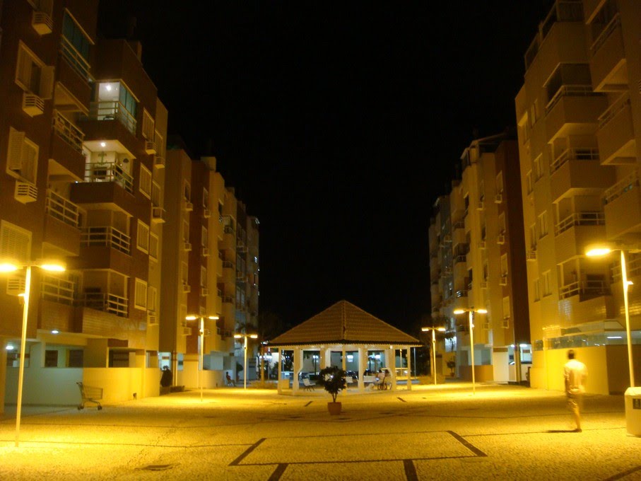 Peatonal de Jurerê y edificios iluminados en la noche / Lautaro by Lautaro Tessi