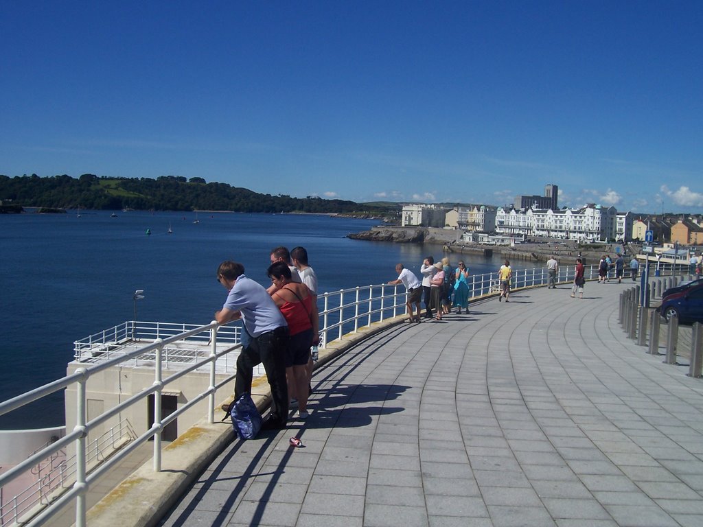 People look out at the boats in glorious sunshine by A Photographer