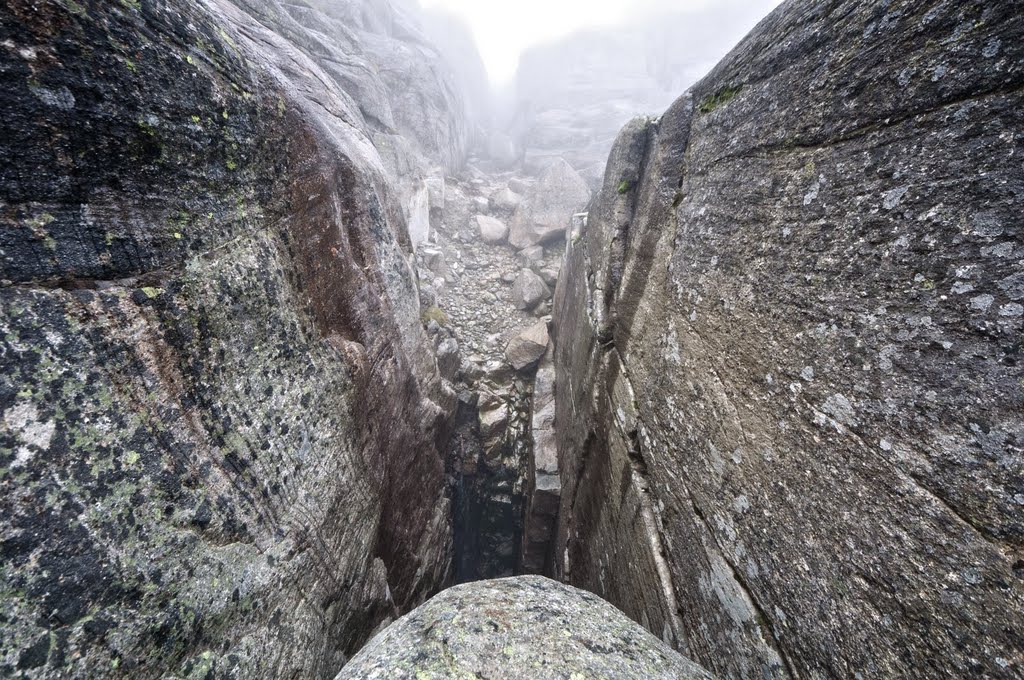 Balancing on a wet and slippery Kjeragbolten, about 1000m up by David Mattiasson