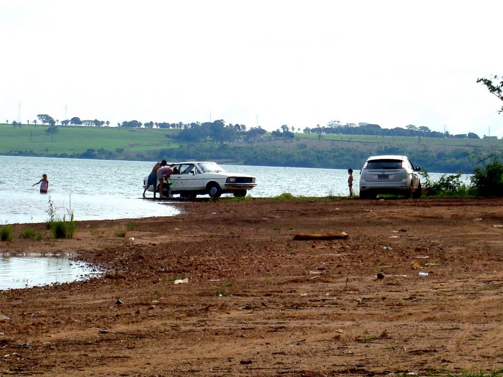 Pessoas lavando o carro nas extremas da Prainha ao fundo terras mineiras by Guilherme Sanders