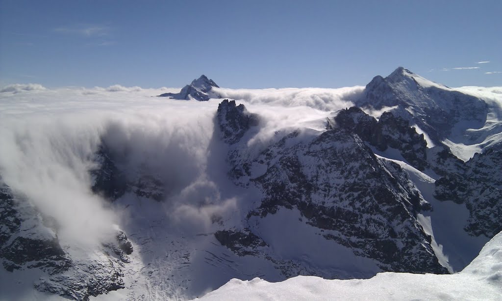 Clouds spilling over the mountains by Harry Oosterveen