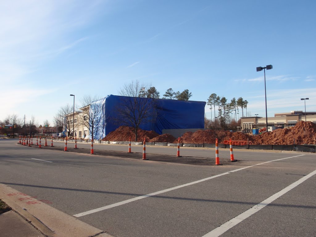 A giant blue tarp on the back side of the new Whole Foods store under construction at the Colonnade development, mirroring the clear sky, and contrasting with the mounds of red clay dirt and the orange cones protecting the new median being built in the middle of Colonnade Center Drive, 1-23-11 by tompope2001