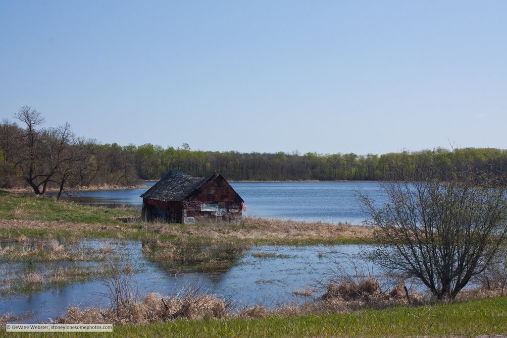 Old building on the edge of a lake by DeVane Webster