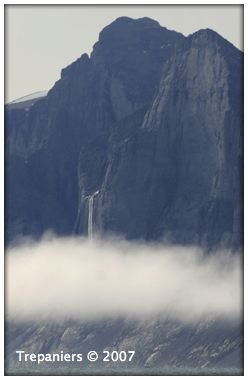 The INTO THE ARCTIC Project. "A waterfall pours out into the fog. I was hoping to get up close to this one because it looked very interesting the way it was situated on the side of the mountain. But high winds, and therefore rough waters kept me from getting any closer." Artist Cory Trepanier, August 2007, http://www.intothearctic.com by CoryTrepanier