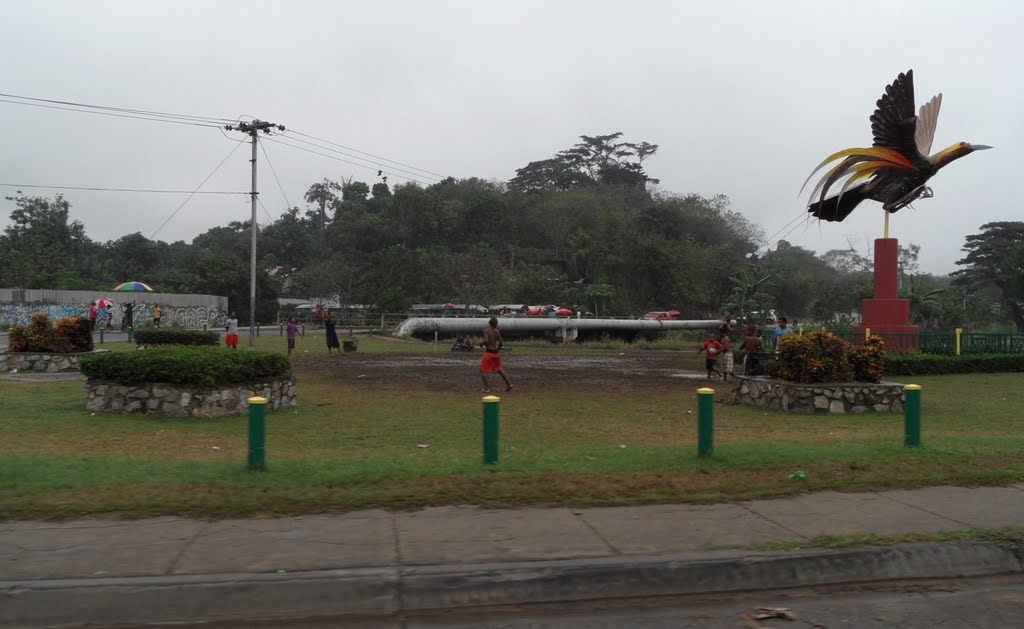 Young Boys Playing on small Muddy Park area on Corner of Hubert Murray Highway on left and Geauta Drive in ERIMA, with Bird of Paradise Statue on right, on 14-06-2011 by Peter John Tate,