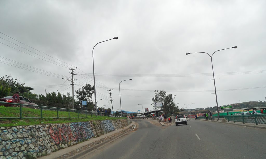 Heading down Hubert Murray Highway into BOROKO, with PMV Bus Terminal Entrance coming up on left, and Overhead Walkway ahead between Terminals on each side of road in BOROKO, Port Moresby, on 18-06-2011 by Peter John Tate,