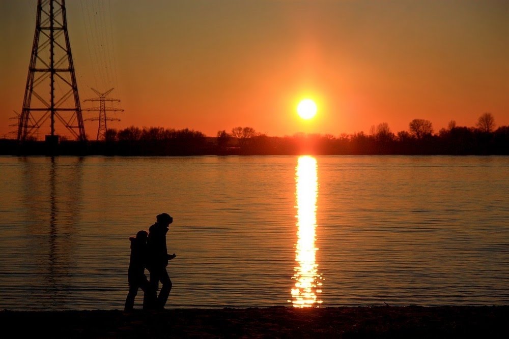 The sun sinks into the river by Claus Klimaschewski