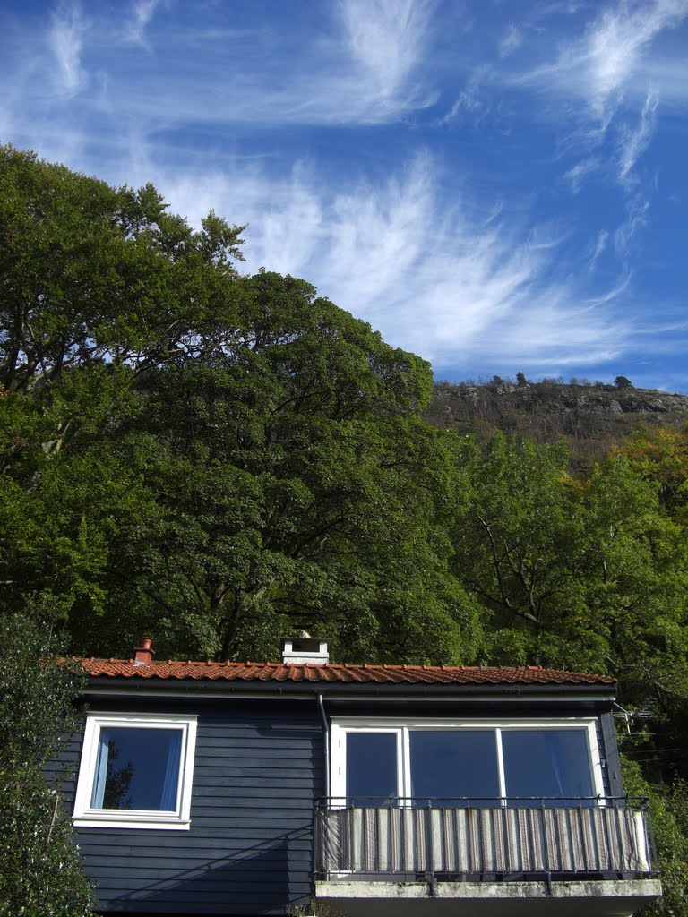 A blue house and beautiful clouds by Mona Lygre