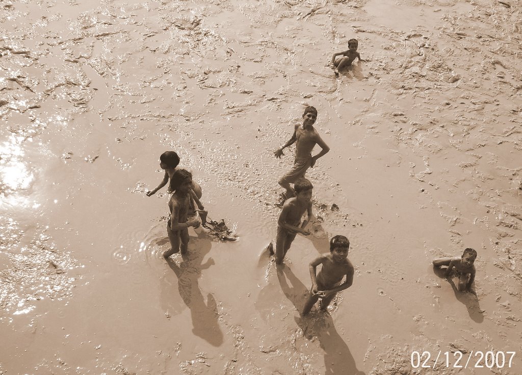 THESE CHILDREEN STANDS THROUGHT THE DAY TO COLLECT COIN FROM MUD THROW BY THE PASSENGERS FROM BRIDGE by Namasudra Sarkar