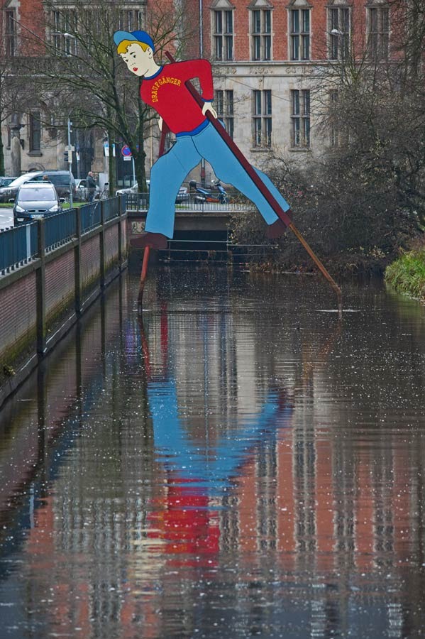 OLDENBURG: «"Der Draufgänger" wagt auf seinen Stelzen den großen Schritt - einen Jahrhundertschritt über den Stau-Graben» / «"Der Draufgänger" (The go-getter) ventures on his stilts the large step - a century step over the "Stau-Graben"» • 12-2011 by hartmut.breitling