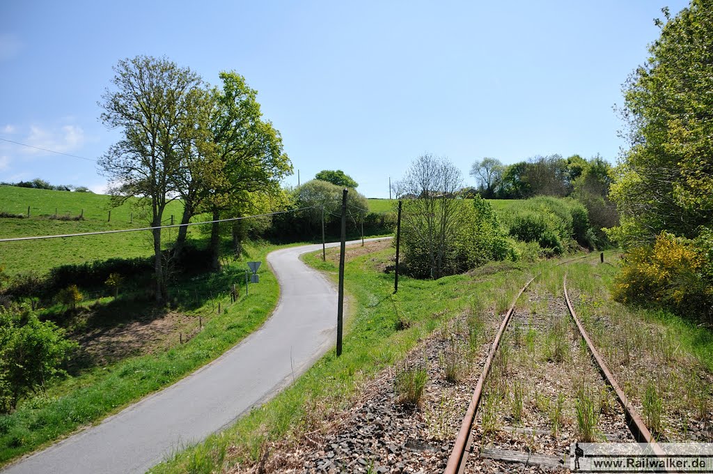 Eine Straße nähert sich dem Bahndamm by Railwalker