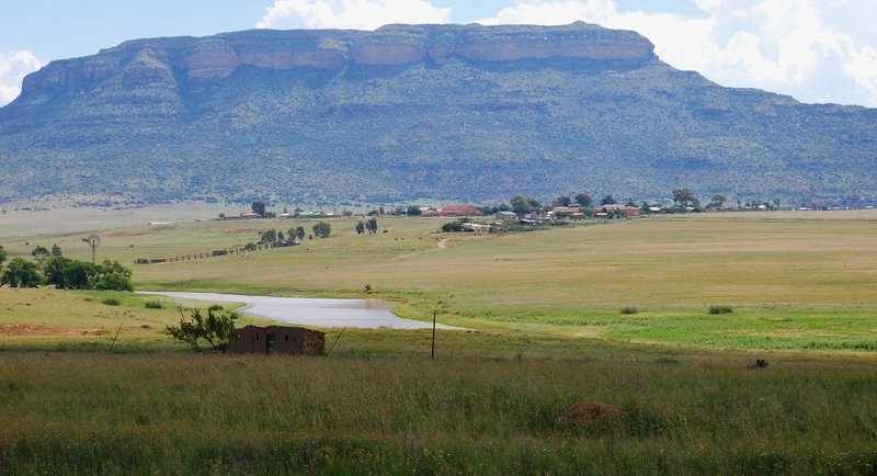 An Abandoned House, a Windpump, a River, and a Village, below Thaba Phatchwa Mountain by ossewa