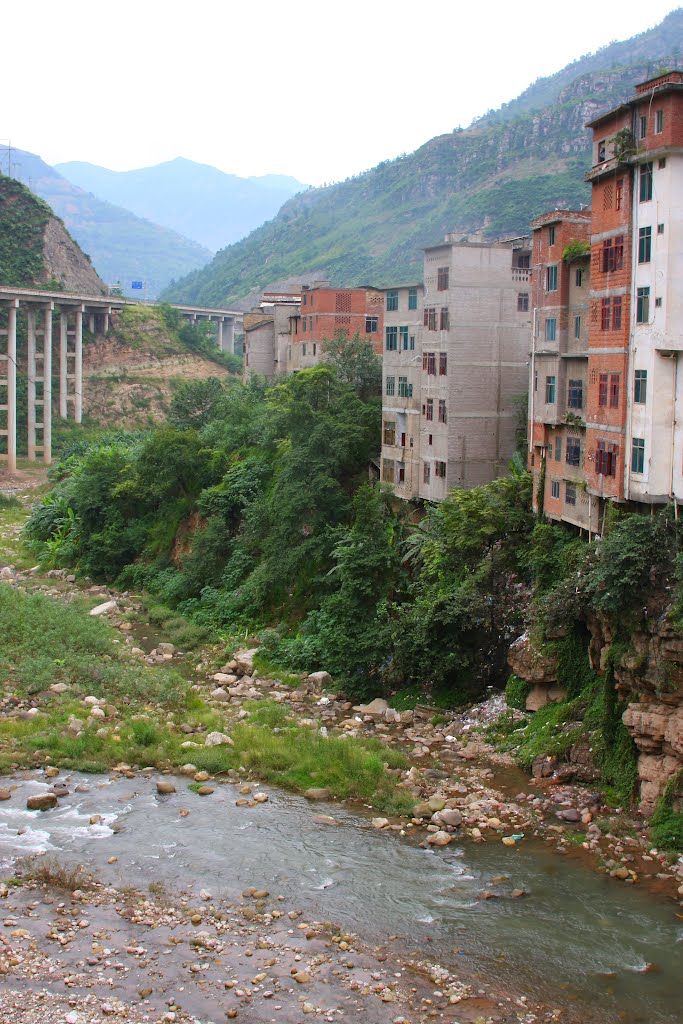 Huixixiang village appartments directly over river in feeding into Jinsha river, China by Paul Snook