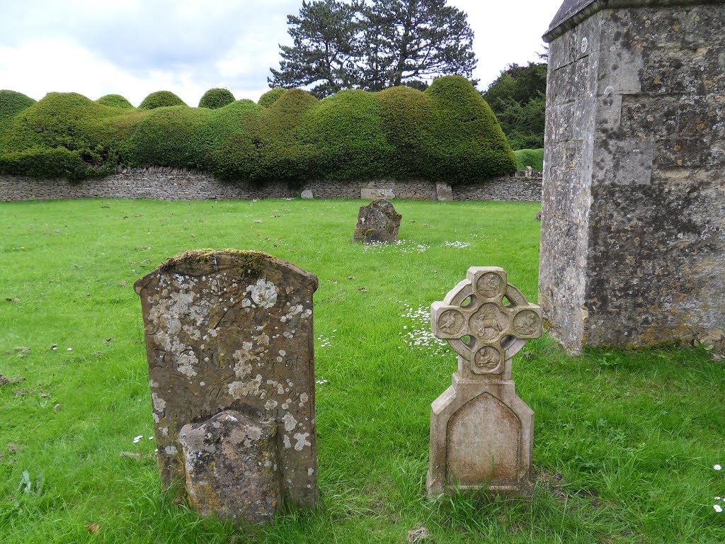 The stone grave markers in All Saints church yard and the back drop of the Cloud cut Yew hedges at Turvey. by Bobsky.