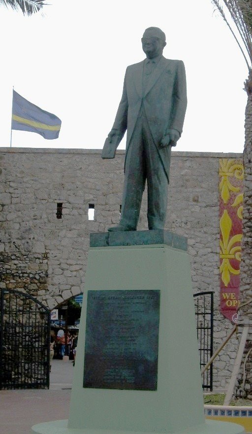 Efraim Jonckheer afgebeeld in het tenue waarin hij bij de VN Het statuut ondertekende waarmee De Nederlandse Antillen in 1954 hun zelfstandigheid verwierven. In zijn rechter hand het ondertekende statuut. by Feika