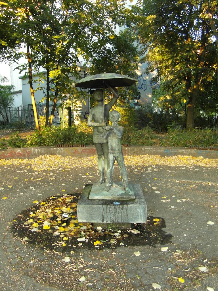 Kinder unter einem Regenschirm - kleiner versteckter Brunnen an der Ecke Prenzlauer Allee / Danziger Straße by IngolfBLN