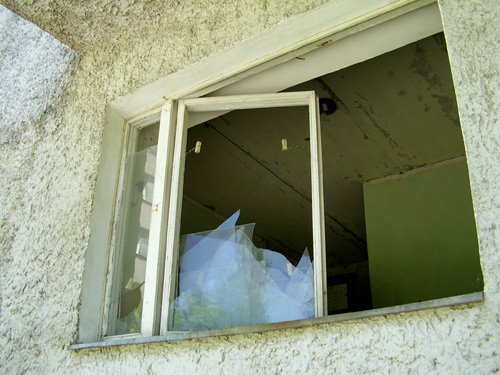 The broken window of former shop by IPAAT