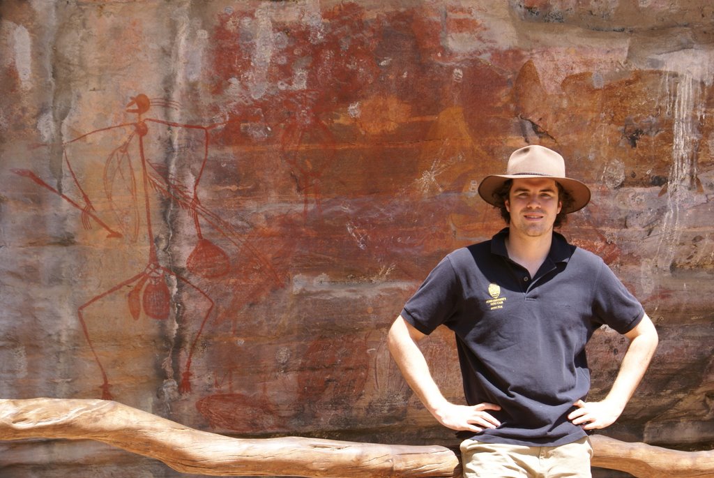 Tim with aboriginal rock art, Ubirr, Kakadu by Peter Watts