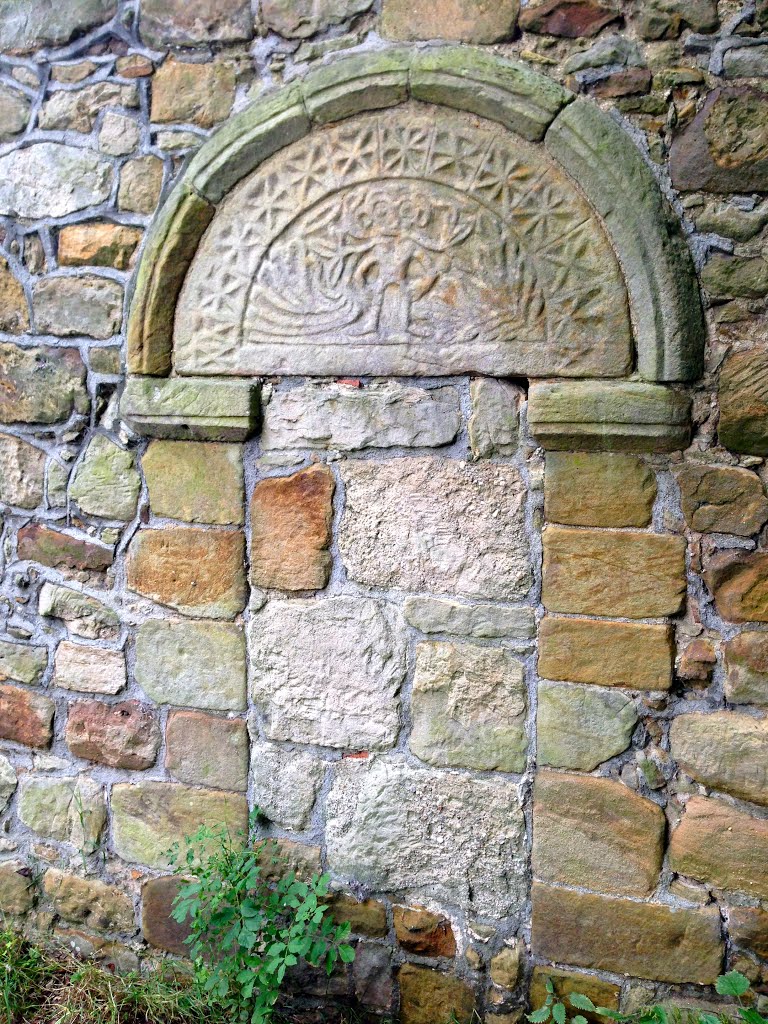 The blocked north doorway with weathered tympanum features a mysterious green man at the Church of St. Leonard at Linley by pedrocut